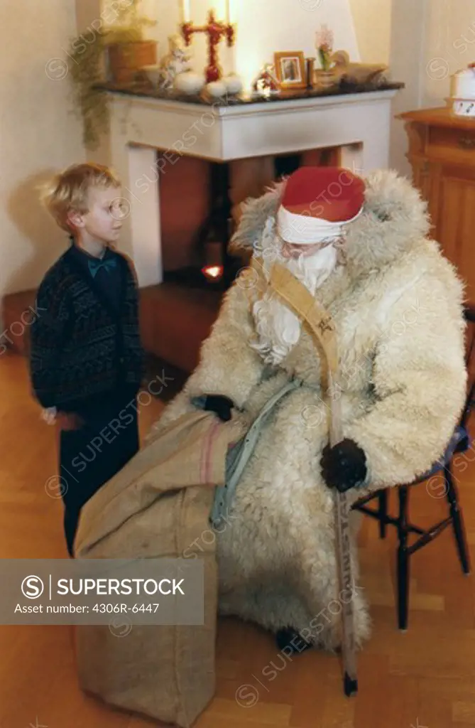 Boy standing next to Santa Claus on Christmas Eve