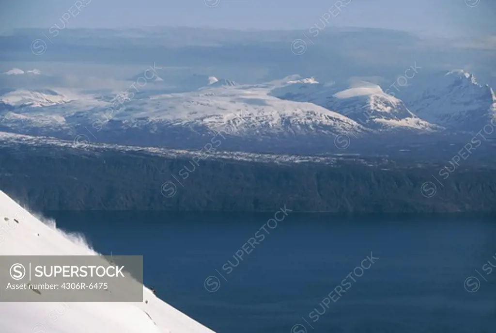 View of fjord with snow covered mountains in winter