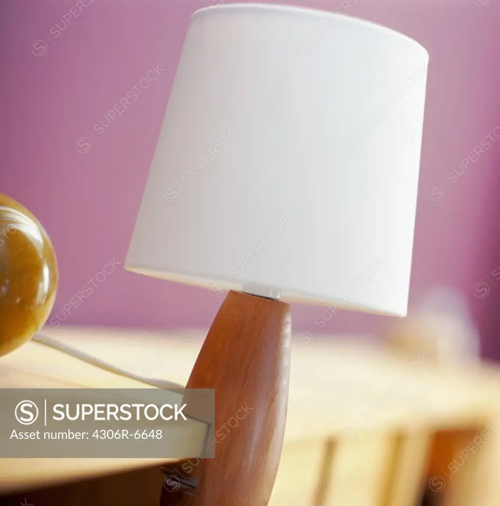 White lampshade on wooden shelf