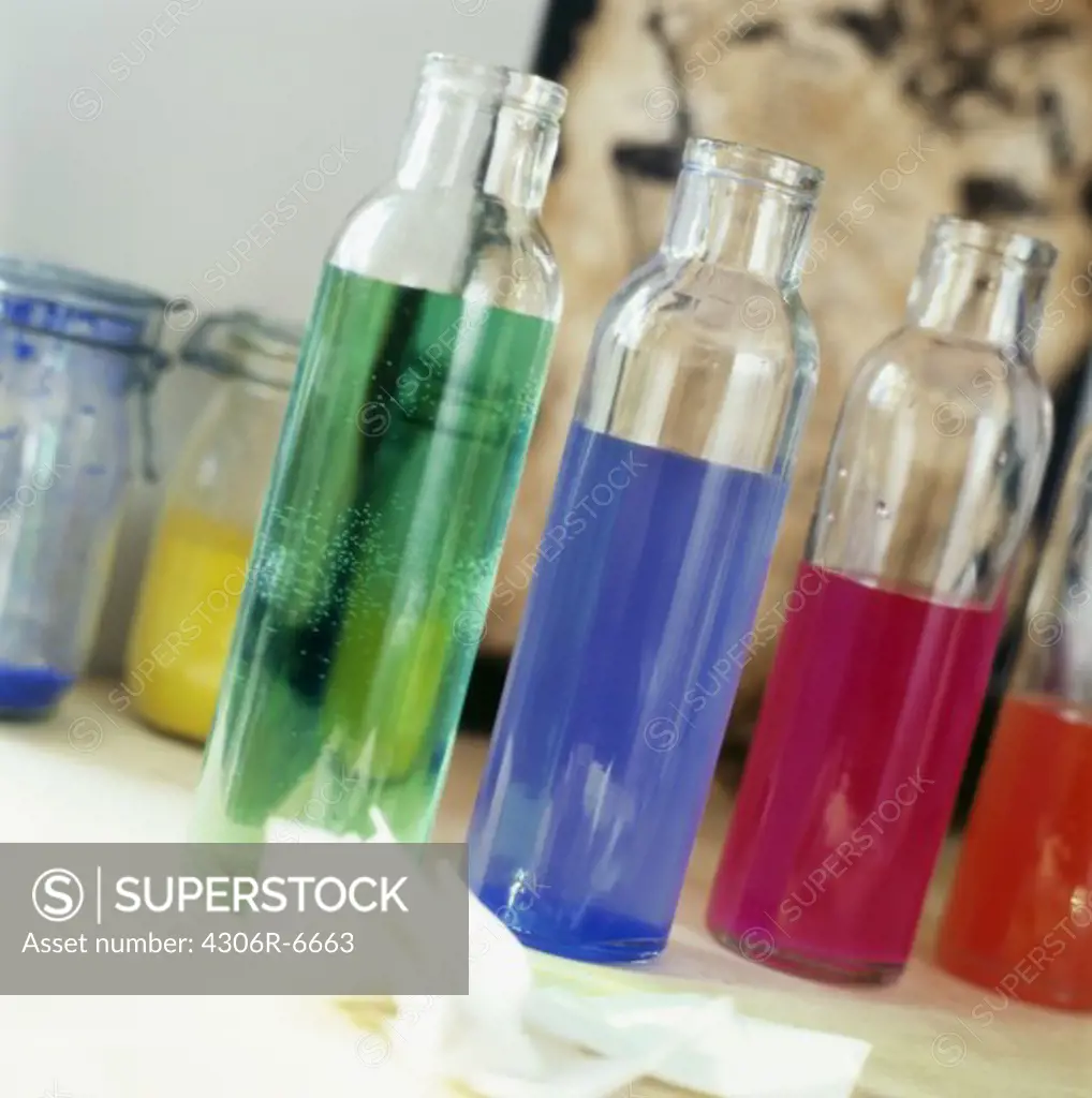 Rows of glass bottle with multicoloured liquid