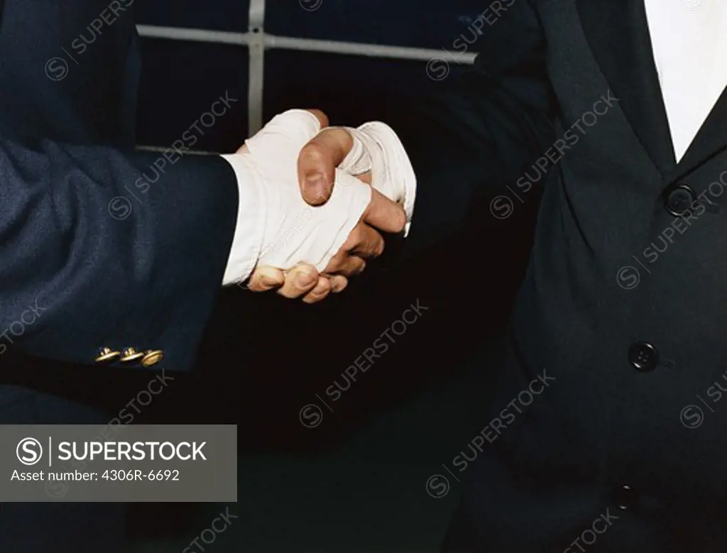 Two people wearing bandages shaking hands