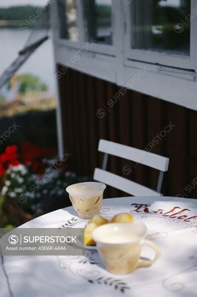 Cups and plate of snacks on outdoor dining table