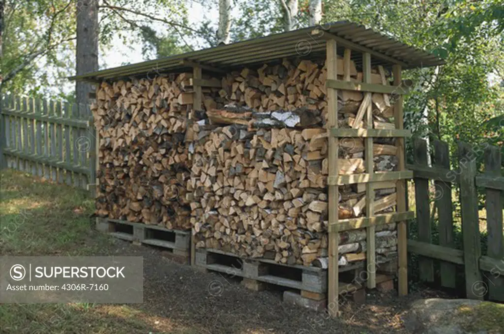 Stack of logs in wooden shed