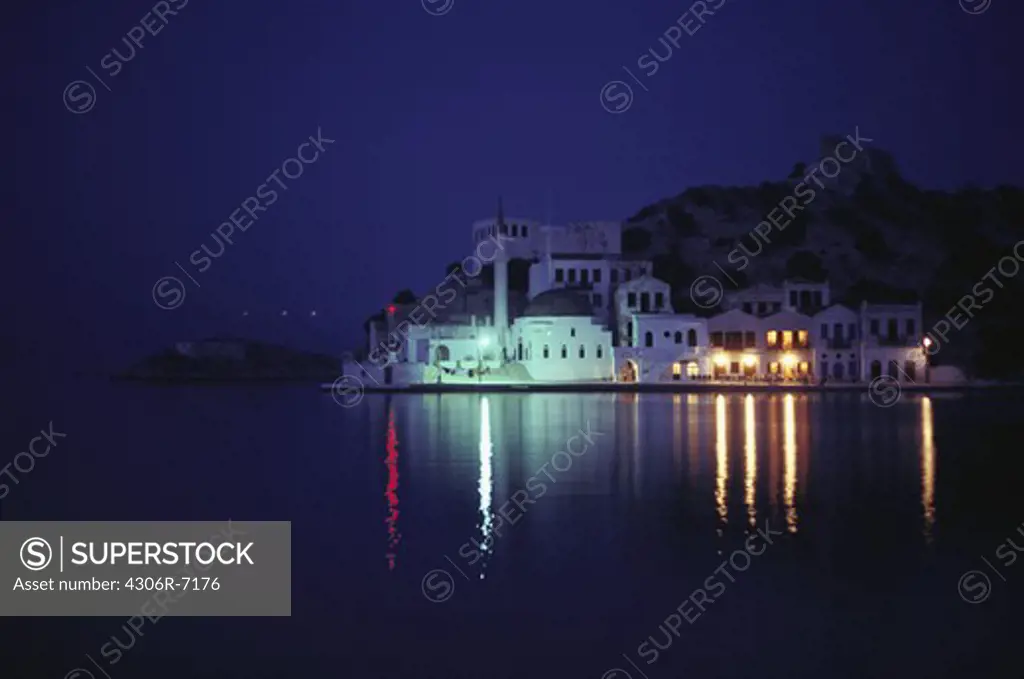 Illuminated hotel building with sea in foreground