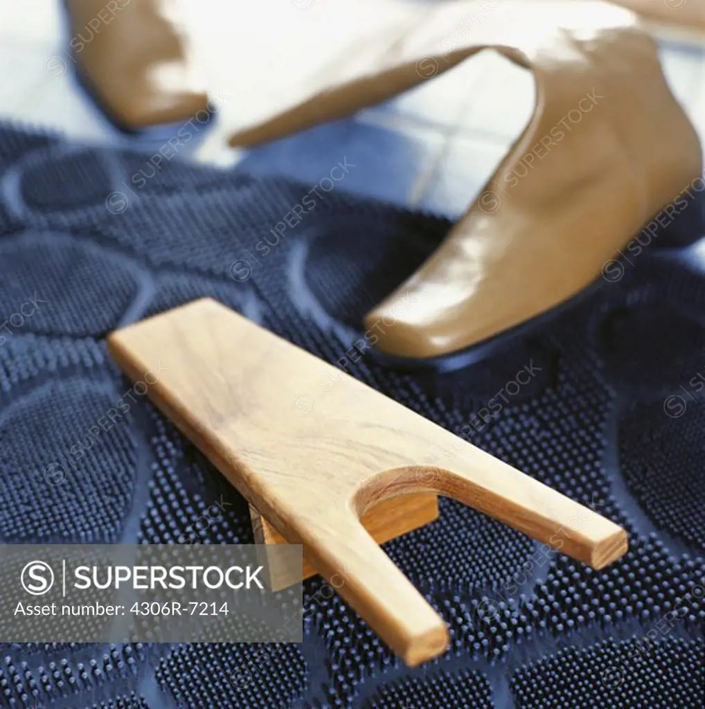 Wooden tool with tan boots in background