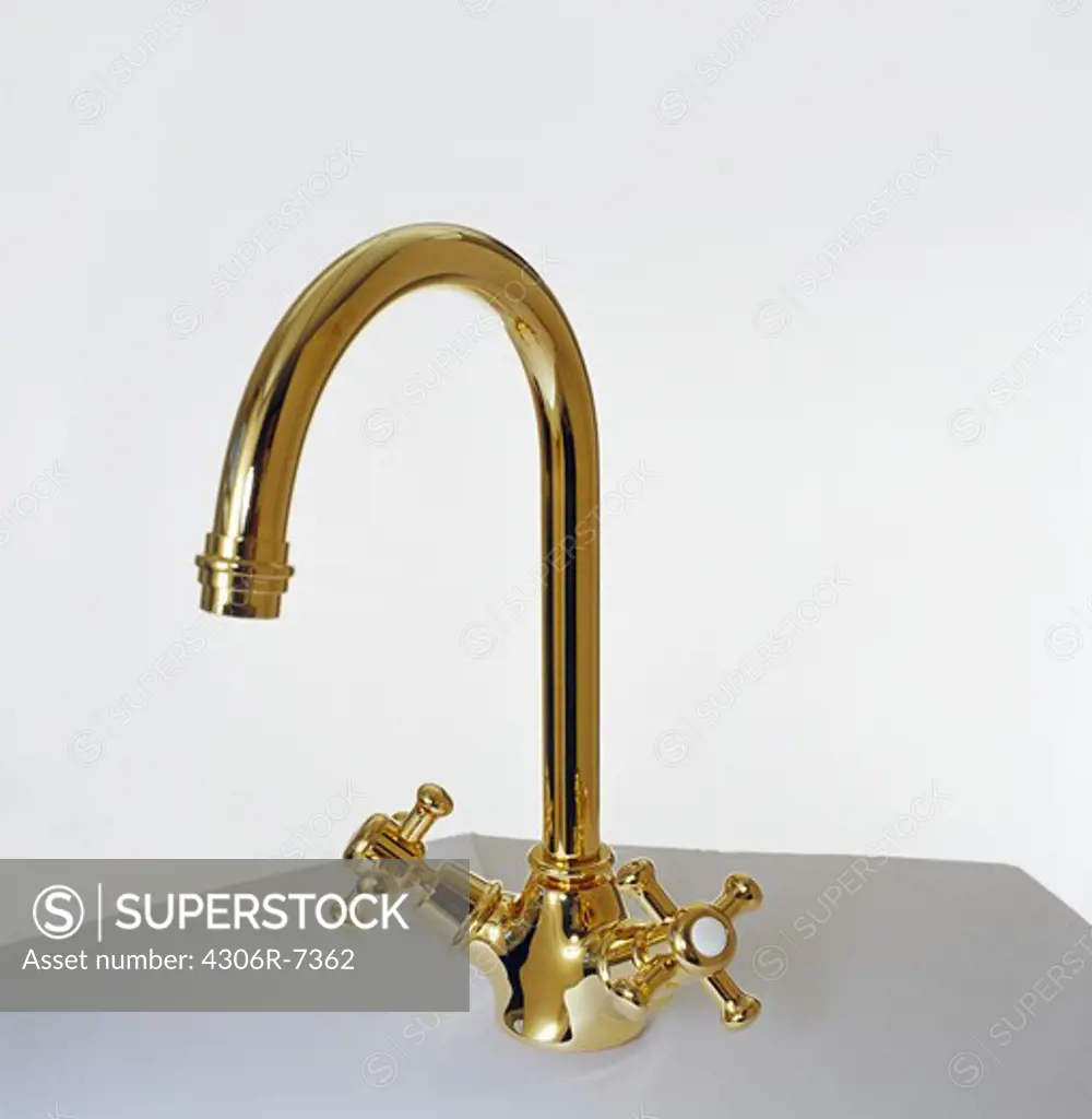 Elegant golden tap against white background