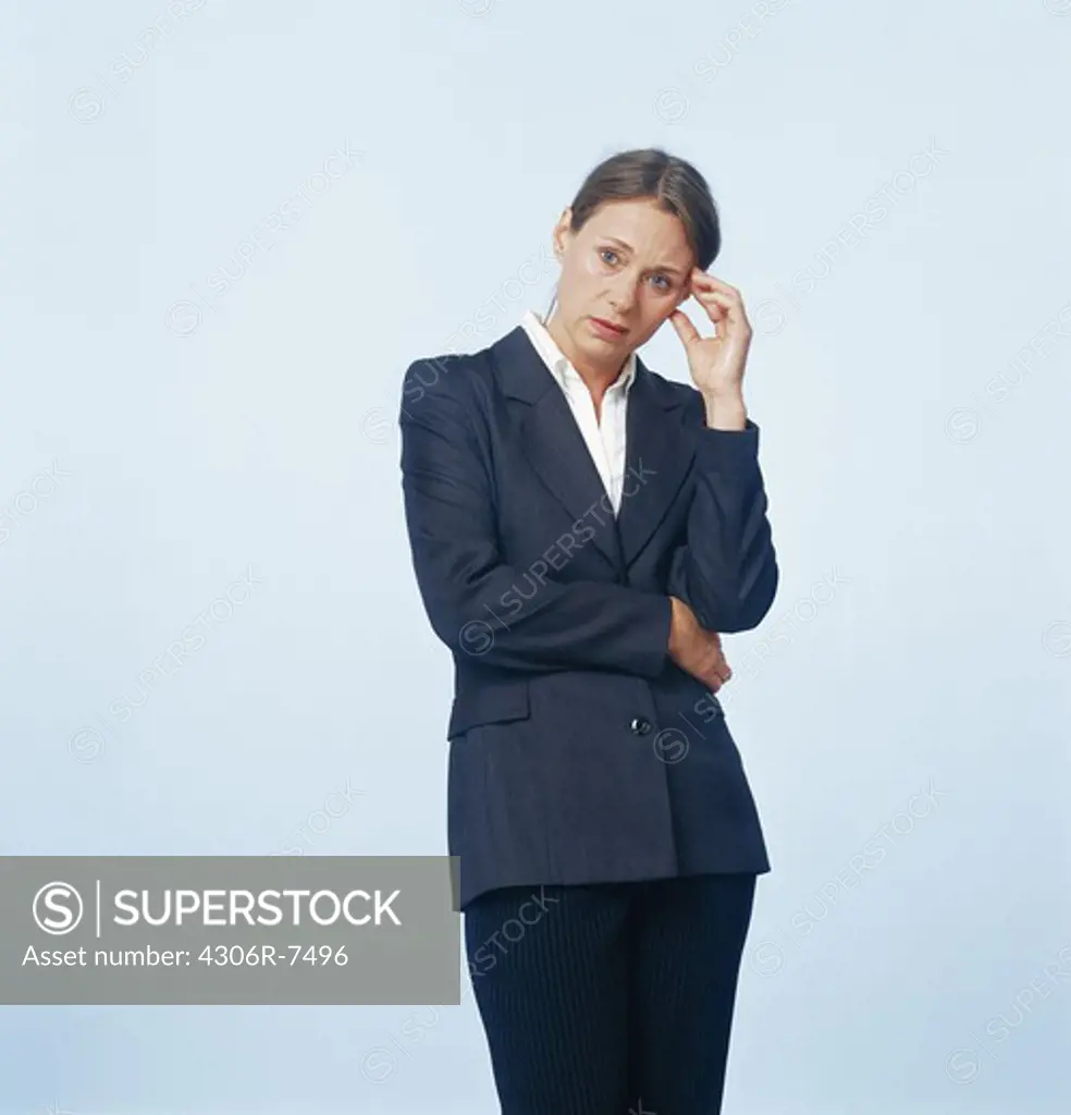 Annoyed businesswoman standing against blue background