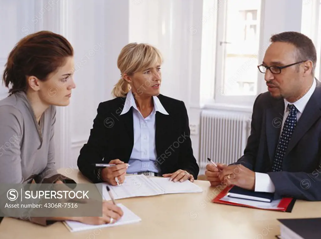 Businessman and women sitting at desk having discussion