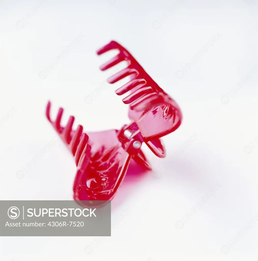Close-up of red hair clip on white background, close-up