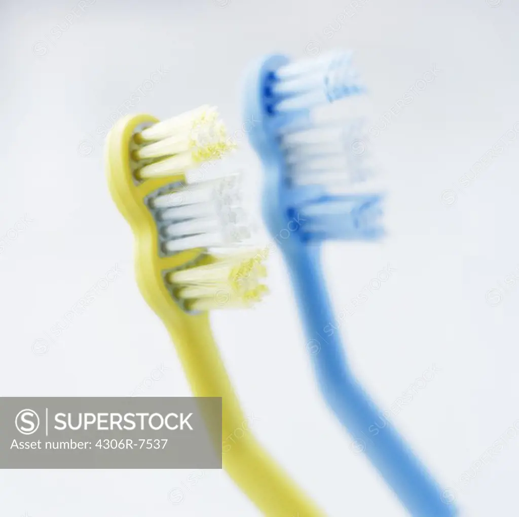 Blue and yellow toothbrushes, close-up