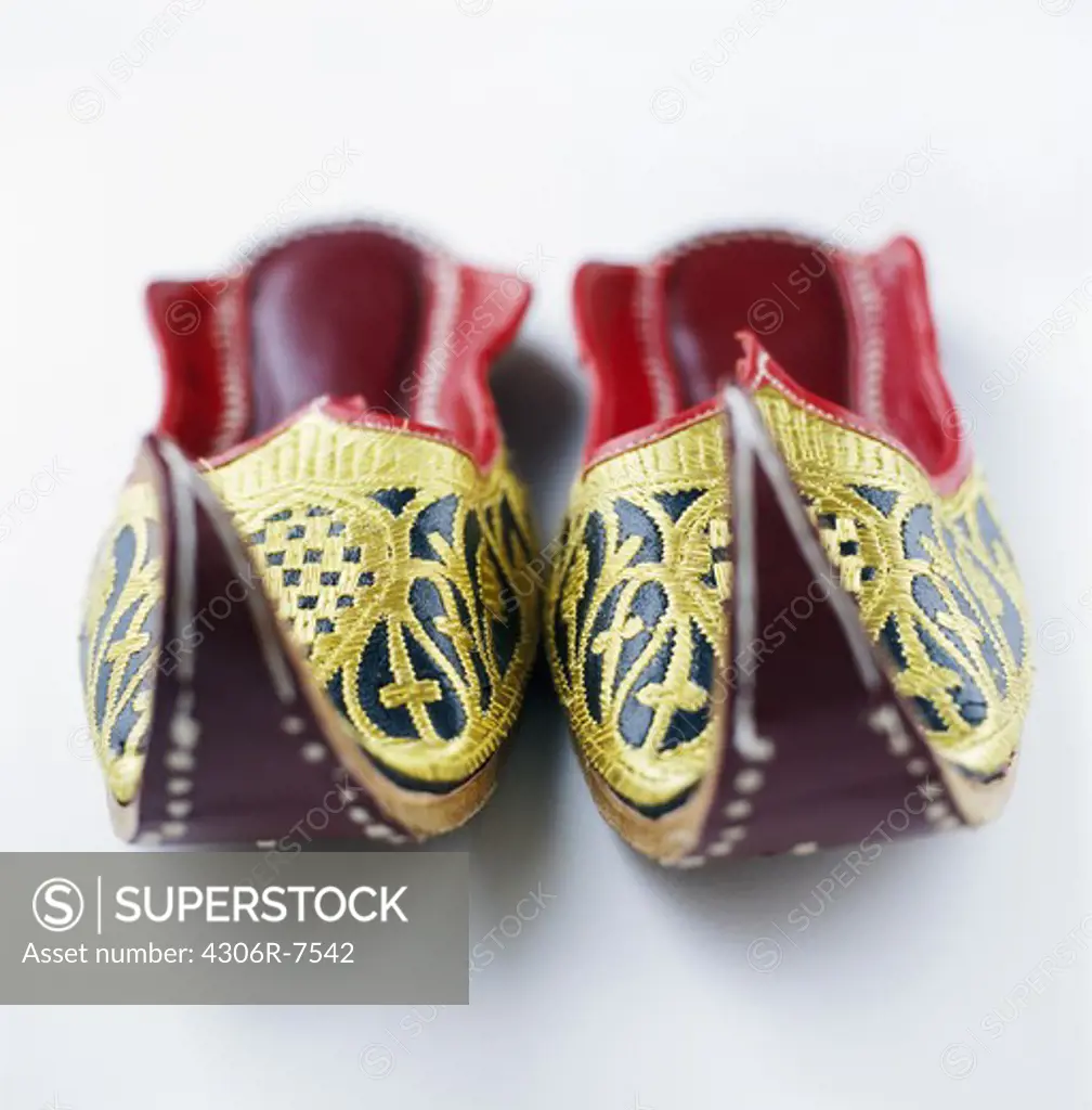 Pair of Indian slippers on white background, close-up