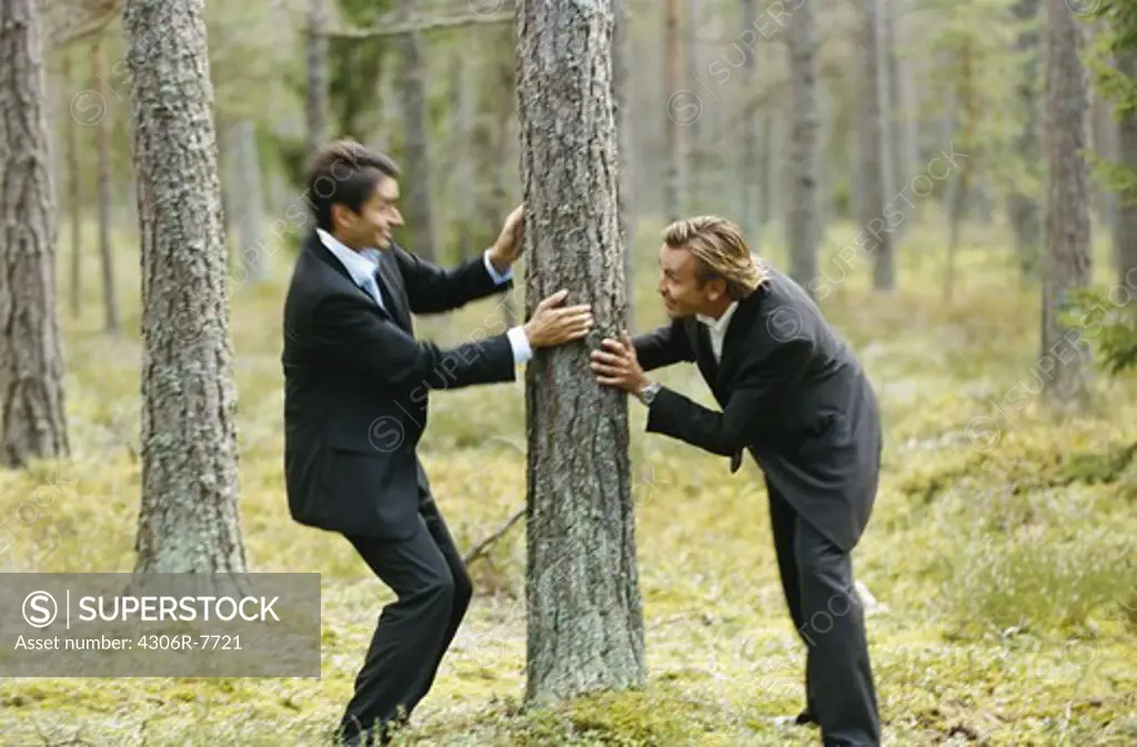 Two businessmen messing about in forest