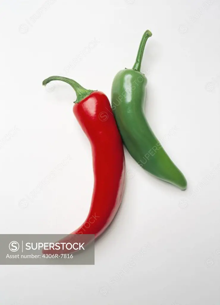 Red and green chilli peppers against white background, close-up