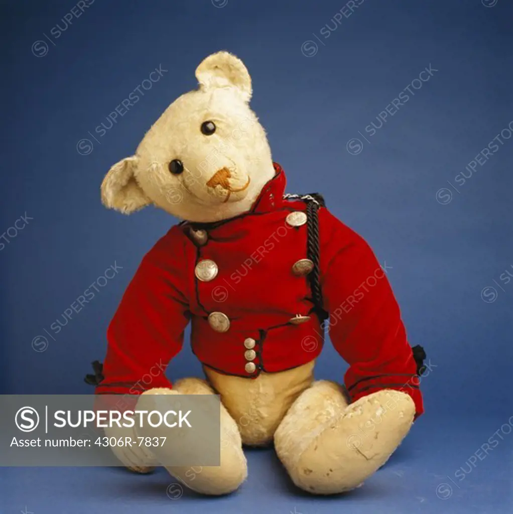 Old fashioned teddy bear against blue background, close-up