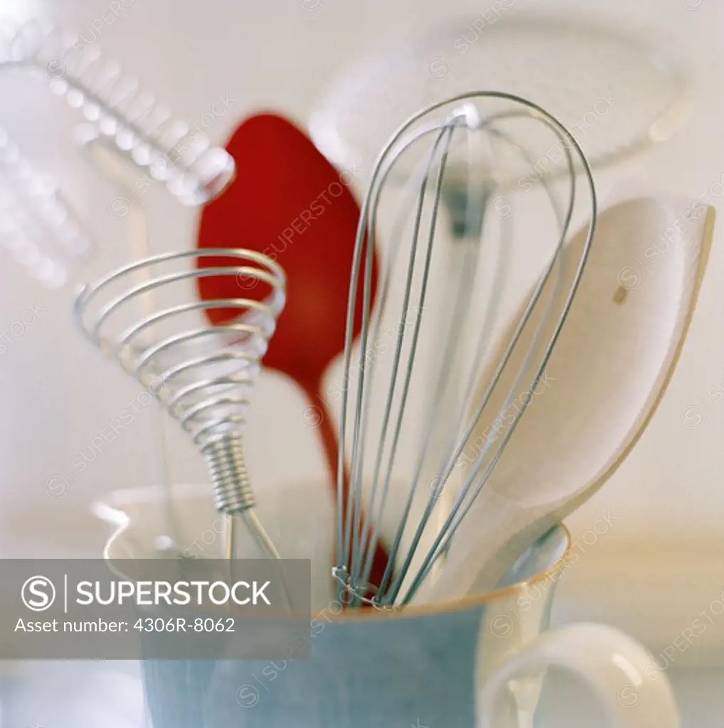 Whisks and spoons in cup, close-up