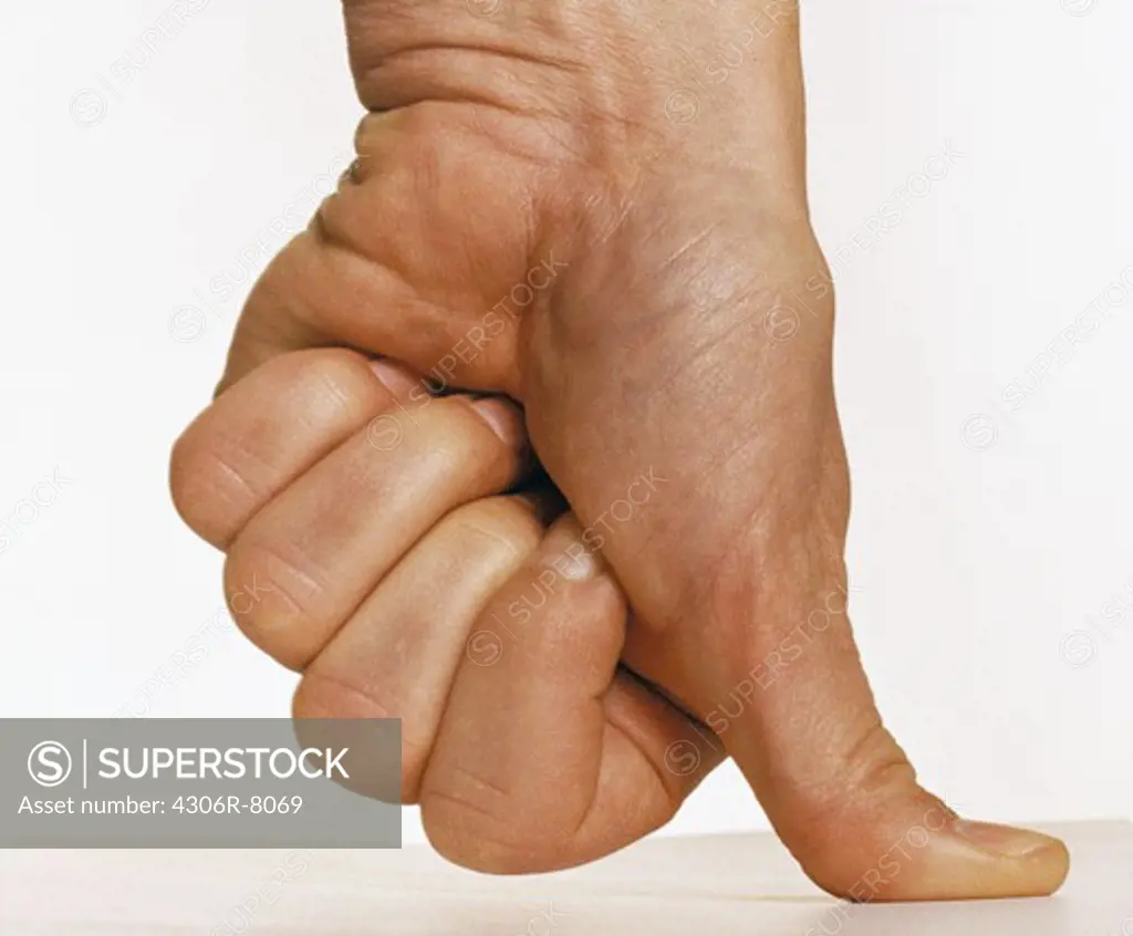 Man pressing thumb against flat surface