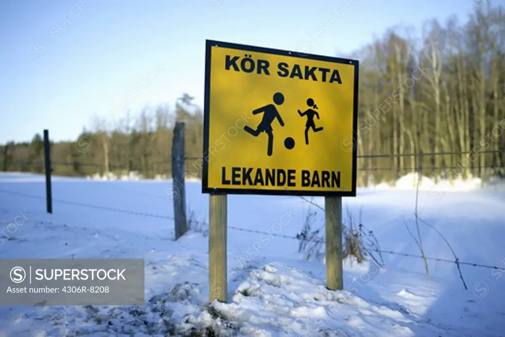 Information signboard in snow with trees in background