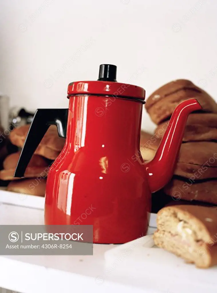 Red coffee pot with sandwiches, close-up