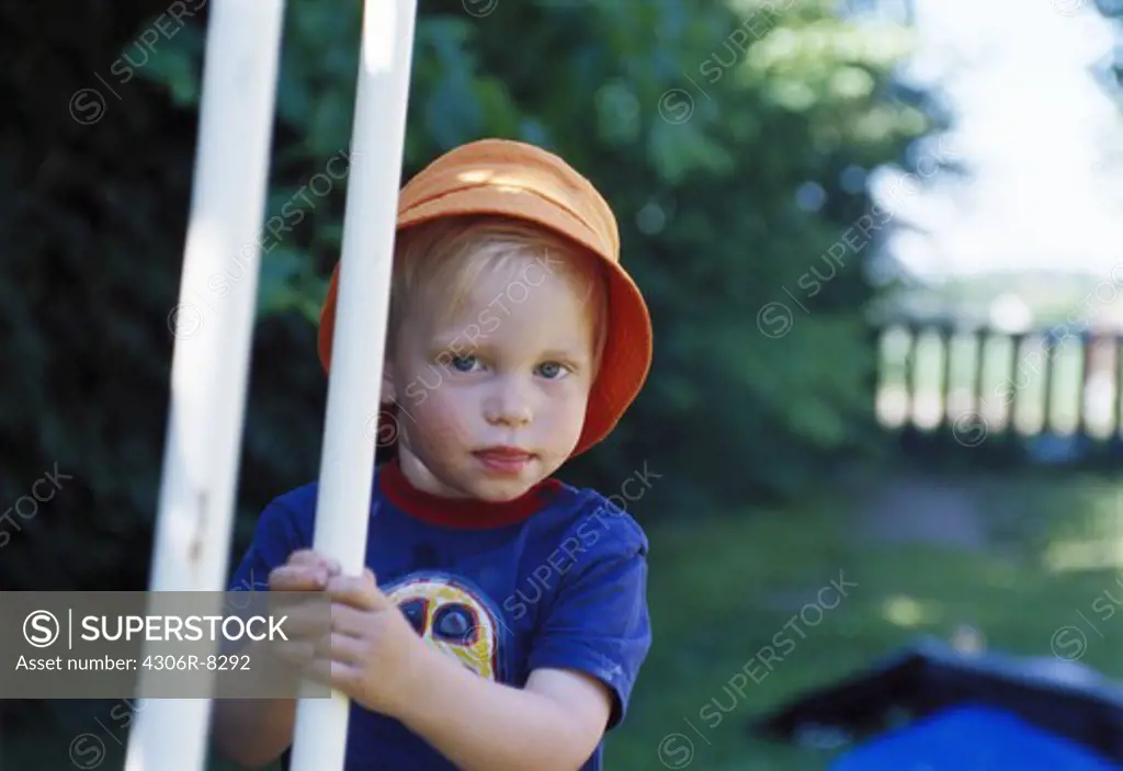 Portrait of boy wearing orange hat in park