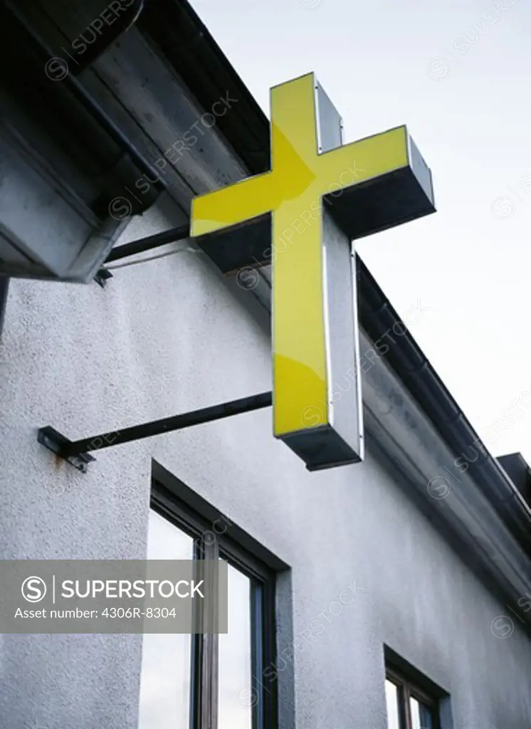 Yellow cross attached to faade of building