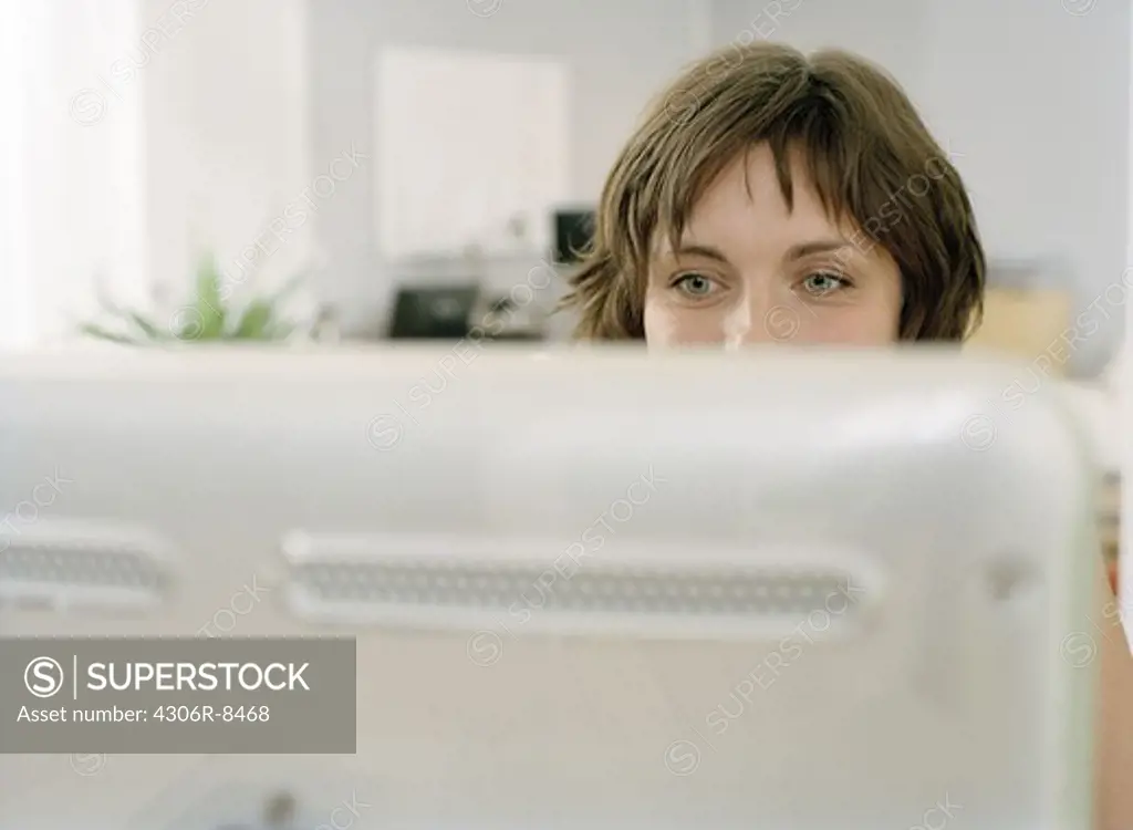 Woman sitting behind computer in office