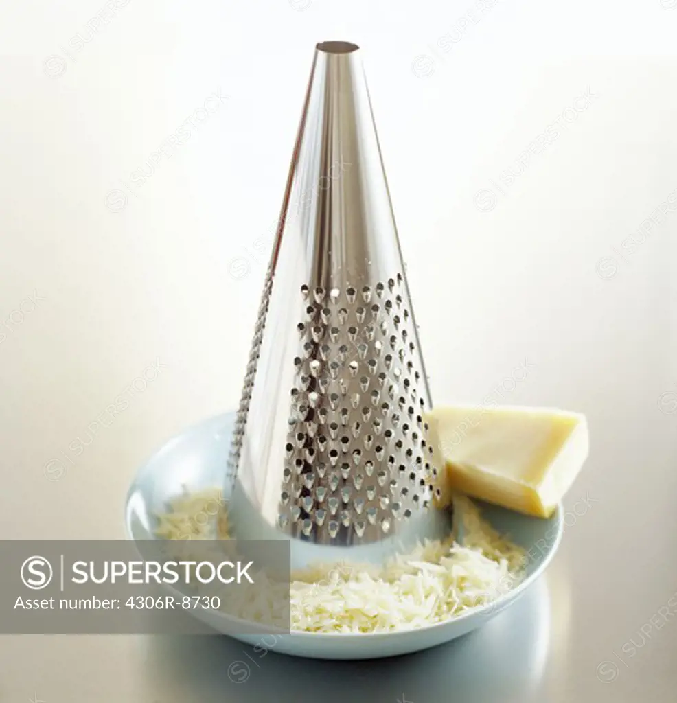 A grater and parmesan cheese, close-up.