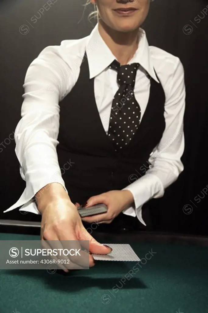 A female croupier handing out cards.