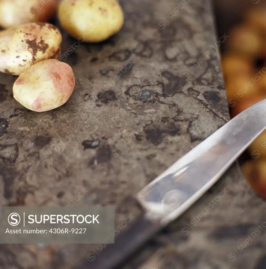 Potatoes and a knife, close-up.
