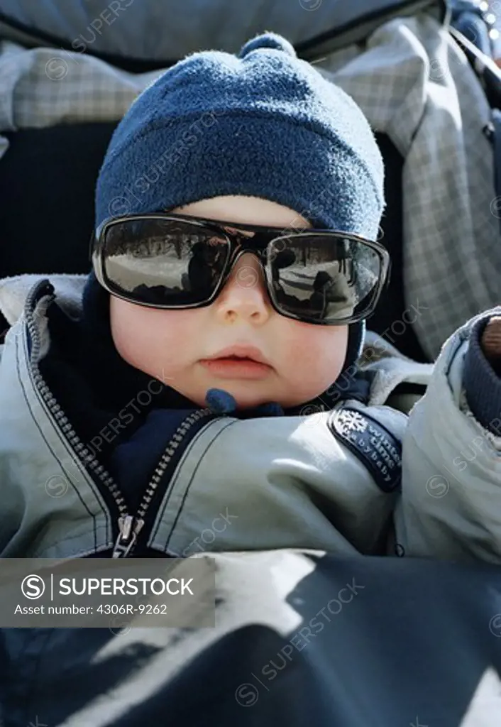 Small girl in sun-glasses and cap.