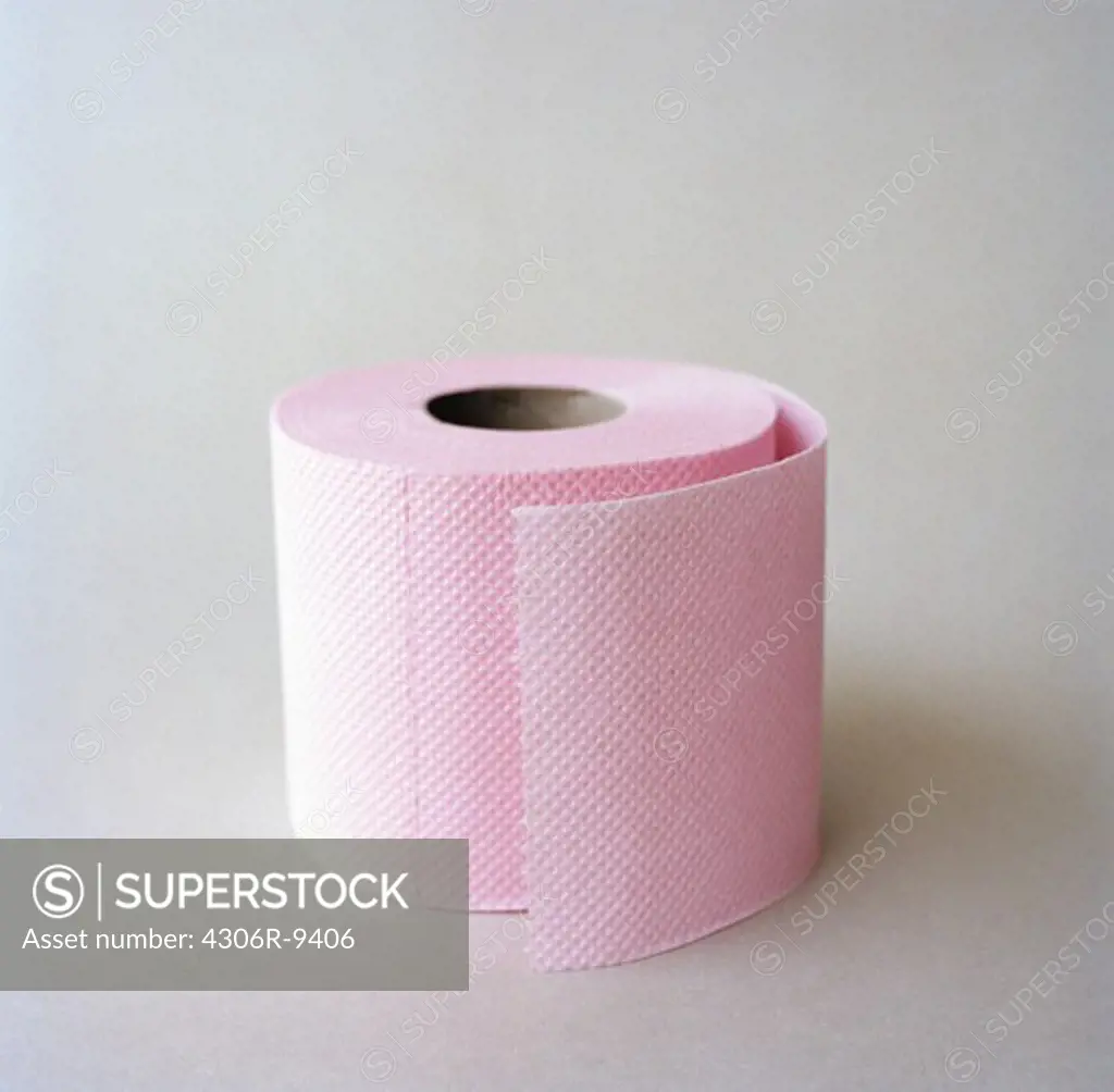 Pink toilet paper on a grey background.