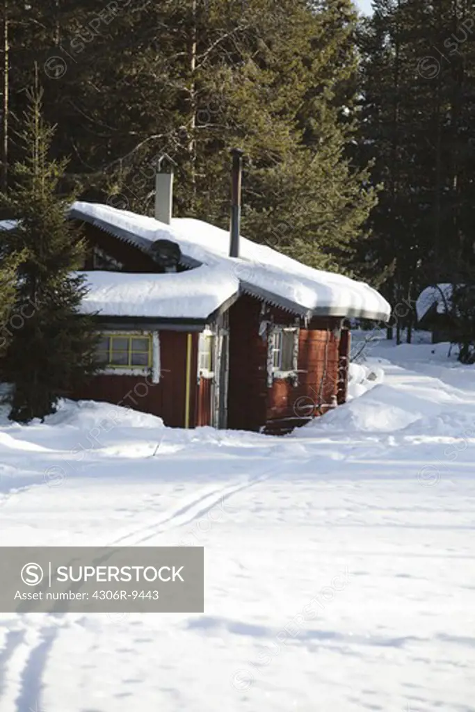 A mountain cabin in a winter landscape.