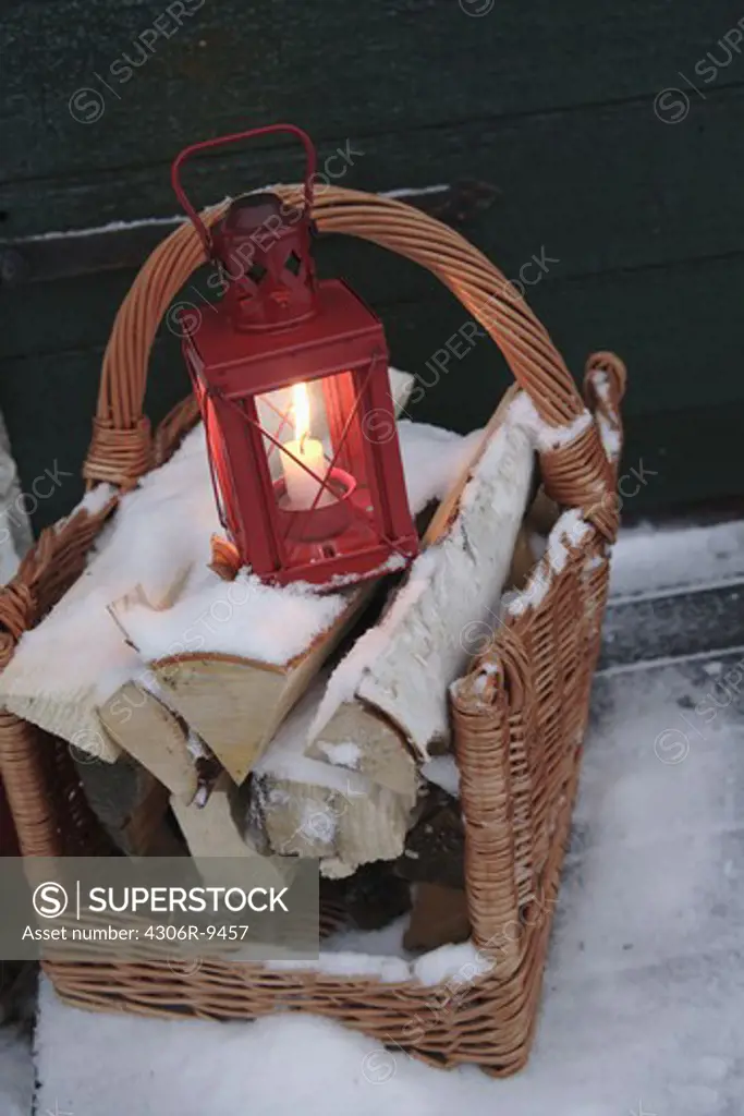 A lantern on a pile of wood.