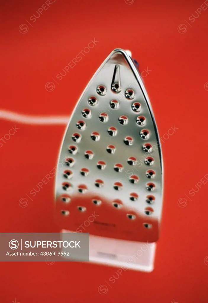 An iron against a red background.