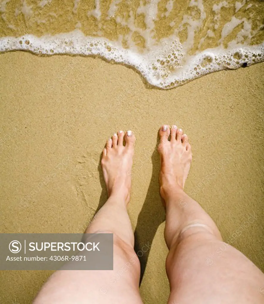 Bare feet on a beach.