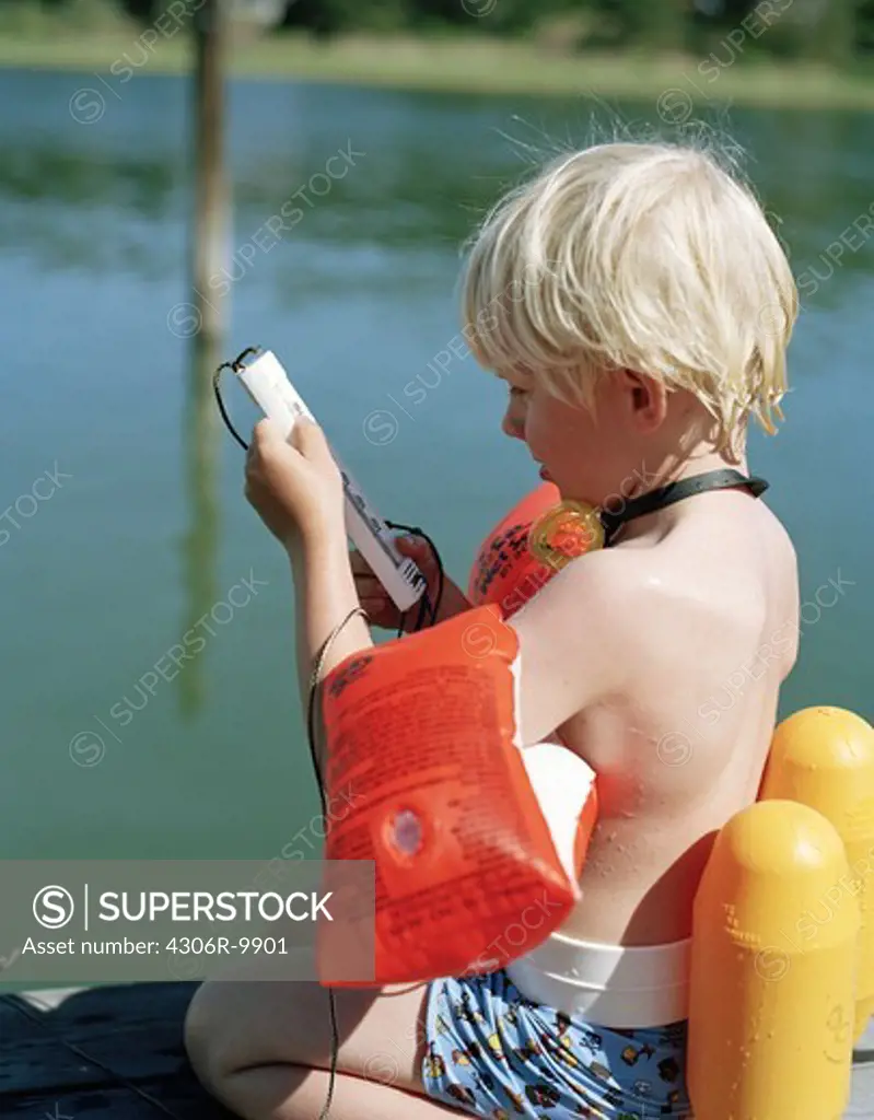 A boy checking the water temperature.