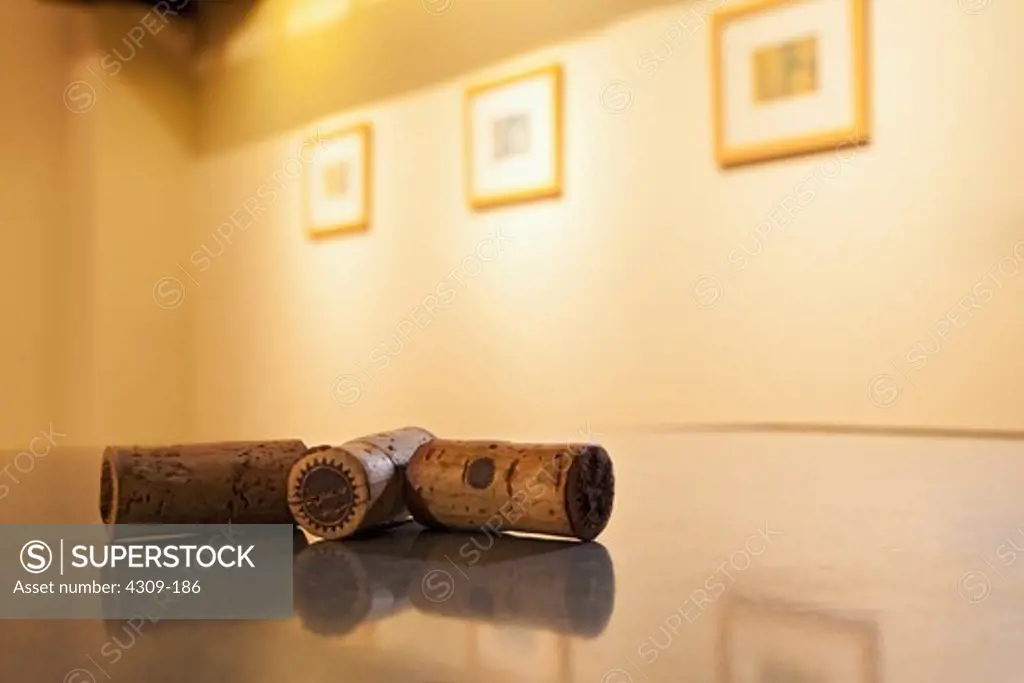 Three used wine corks on a table.
