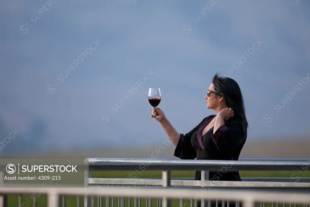 Patricia Bennett gazing at a glass of wine.