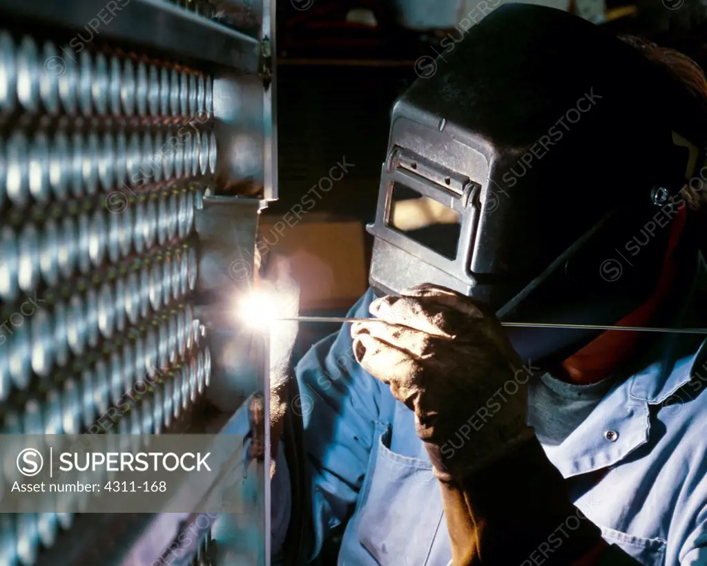 A Welder Performs Gas Tungsten Arc Welding on a Metal Grate