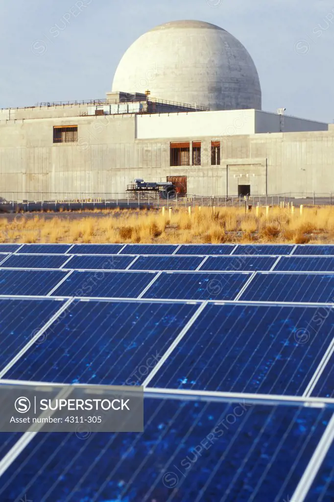 Solar panels at White Bluffs Solar Station with nuclear power plant in the background, Richland, Washington State, USA