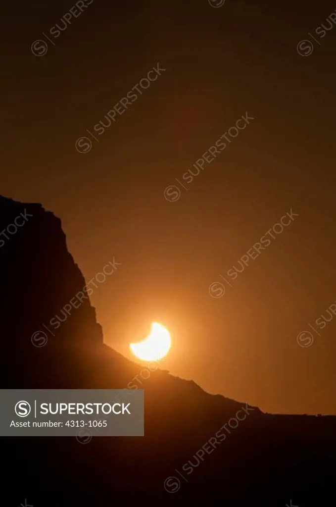 The partially-eclipsed sun sets behind a butte in Monument Valley Tribal Park, on the Utah-Arizona border, following an annular eclipse of the sun on May 20, 2012.