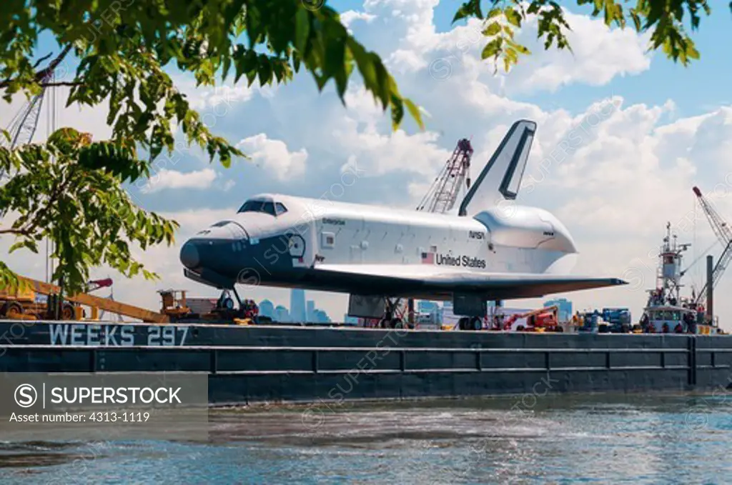 The Space Shuttle prototype Enterprise departs Bayonne after an overnight stop, as it sails by barge from JFK airport to the Intrepid Sea, Air & Space museum on New York City's Hudson River