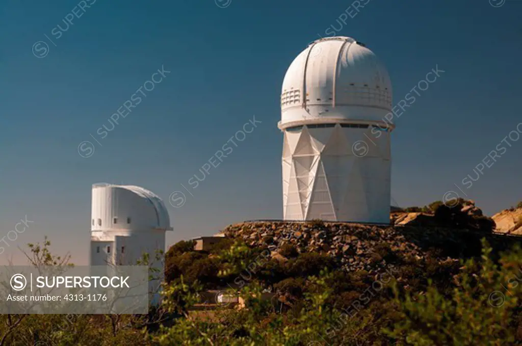 The 4-meter Mayall and 2.3-meter Bok Reflector telescope domes are seen atop Kitt Peak National Observatory, Arizona.