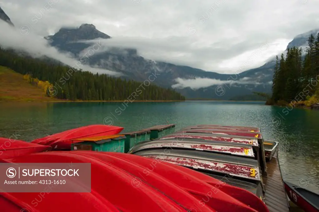 Canada, British Columbia, Red canoes on dock in Emerald Lake, Yoho National Park