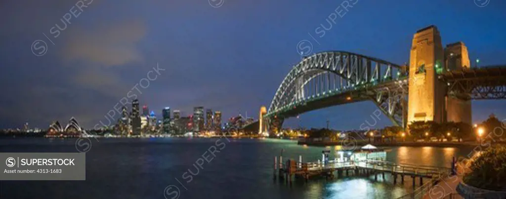 Australia, New South Wales, Sydney. View of Sydney Harbor Bridge, skyline and opera house at night from suburb of Kirribilli