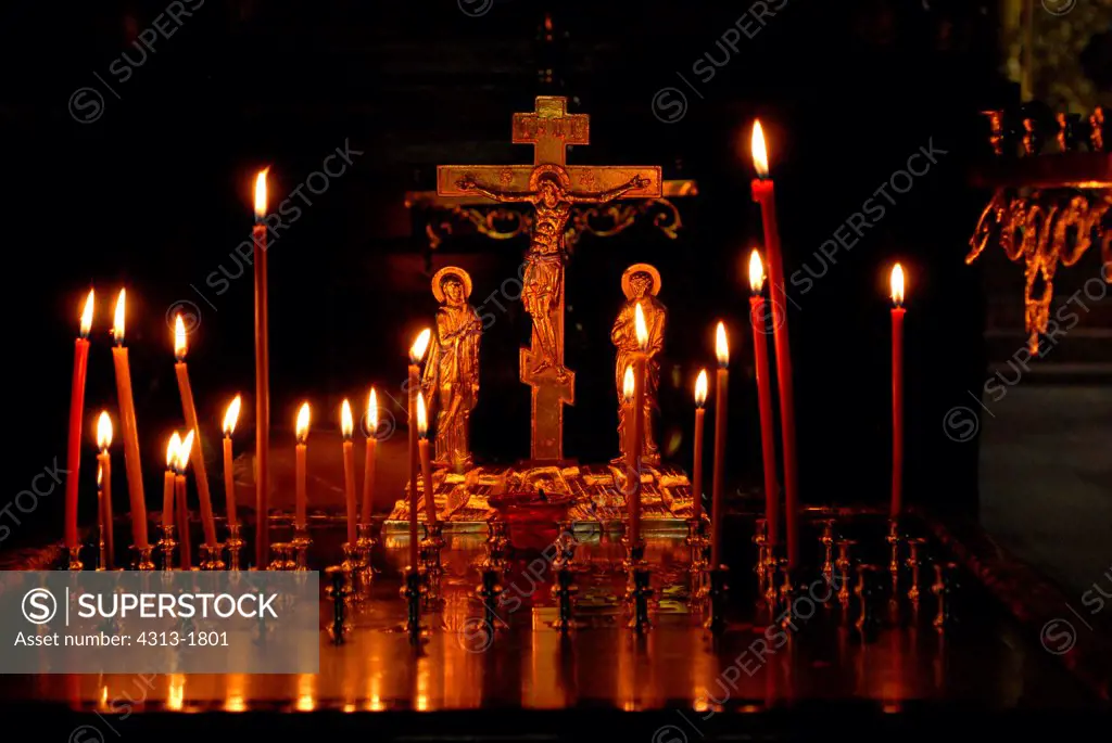 Candles and a gold cross depicting the crucifixion in an orthodox church, Irkutsk, Siberia, Russia