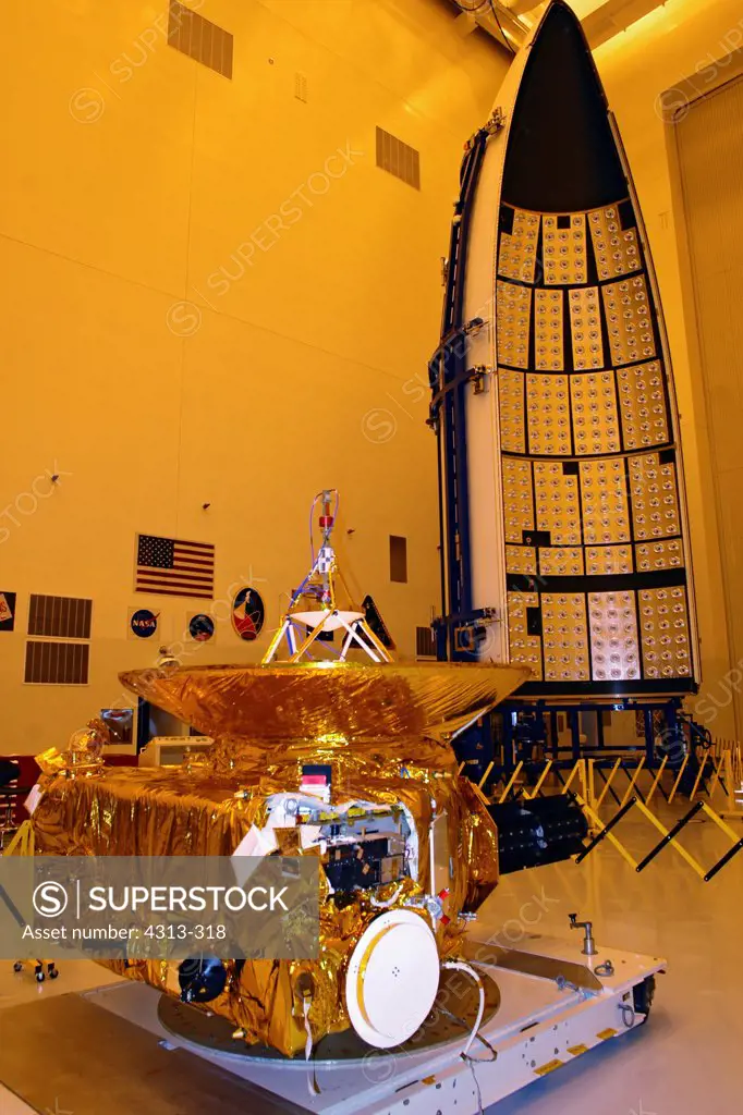NASA's nuclear-powered New Horizons spacecraft, the world's first mission to Pluto, is prepared for launch inside a cleanroom at the Kennedy Space Center. The payload fairing for the Atlas V rocket that will launch it can be seen in the background.