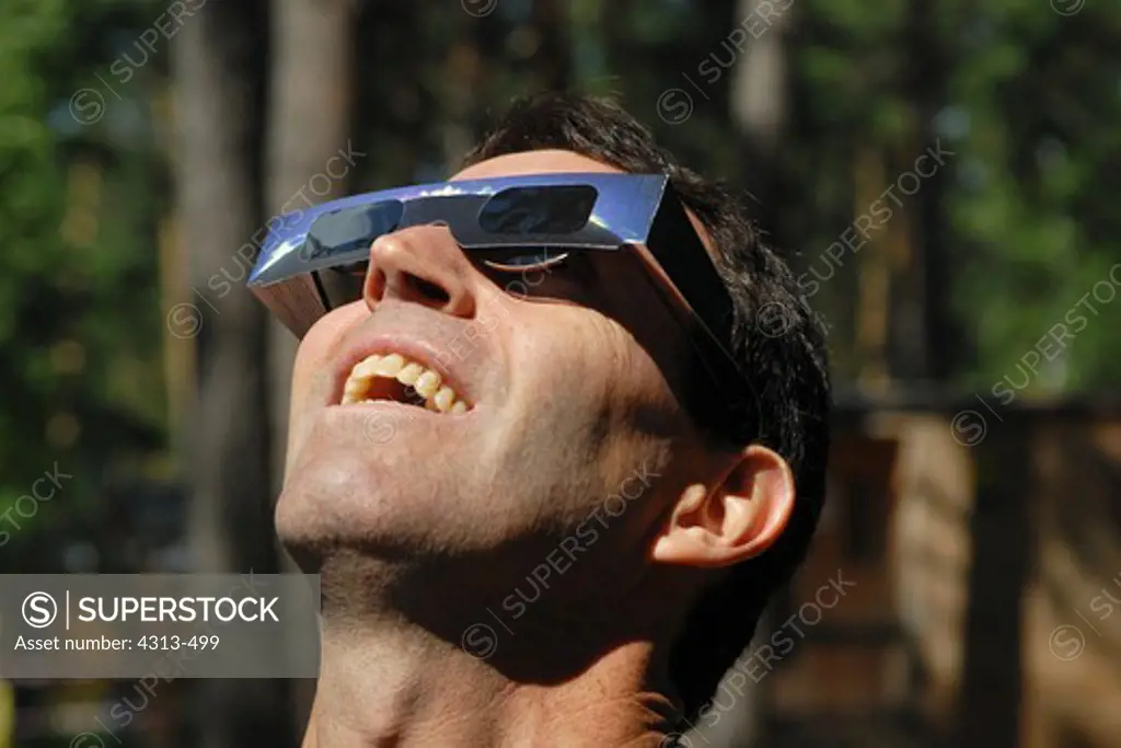 A spectator wearing protective glasses views a total eclipse of the sun over the Ob River, near Novosibirsk, Siberia, Russia, on August 1, 2008.