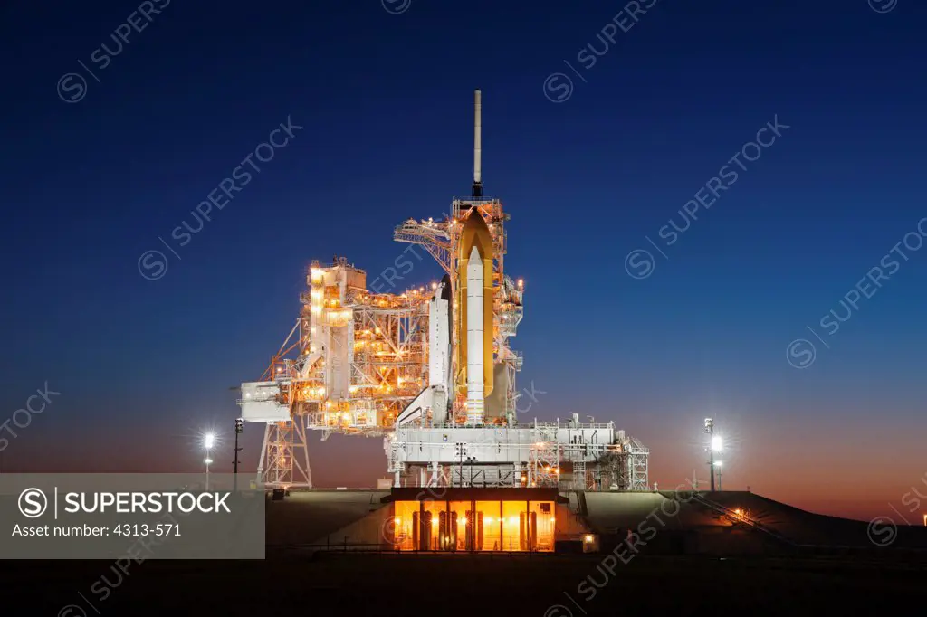 Space shuttle Endeavour stands atop Pad 39A after sunset, following a launch scrub for STS-134.