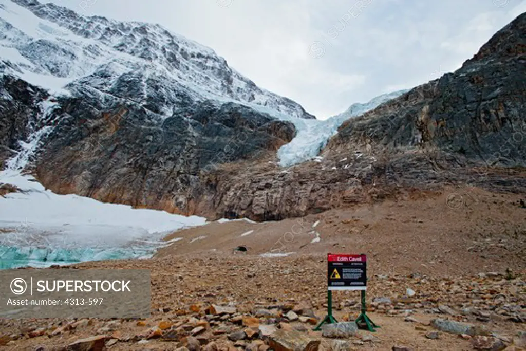 A sign warns of the dangers of approaching Angel Glacier, where chunks of ice calve from the melting glacier at the base of Mount Edith Cavell. The entire valley was occupied by glacier as recently as fifty or less years ago.
