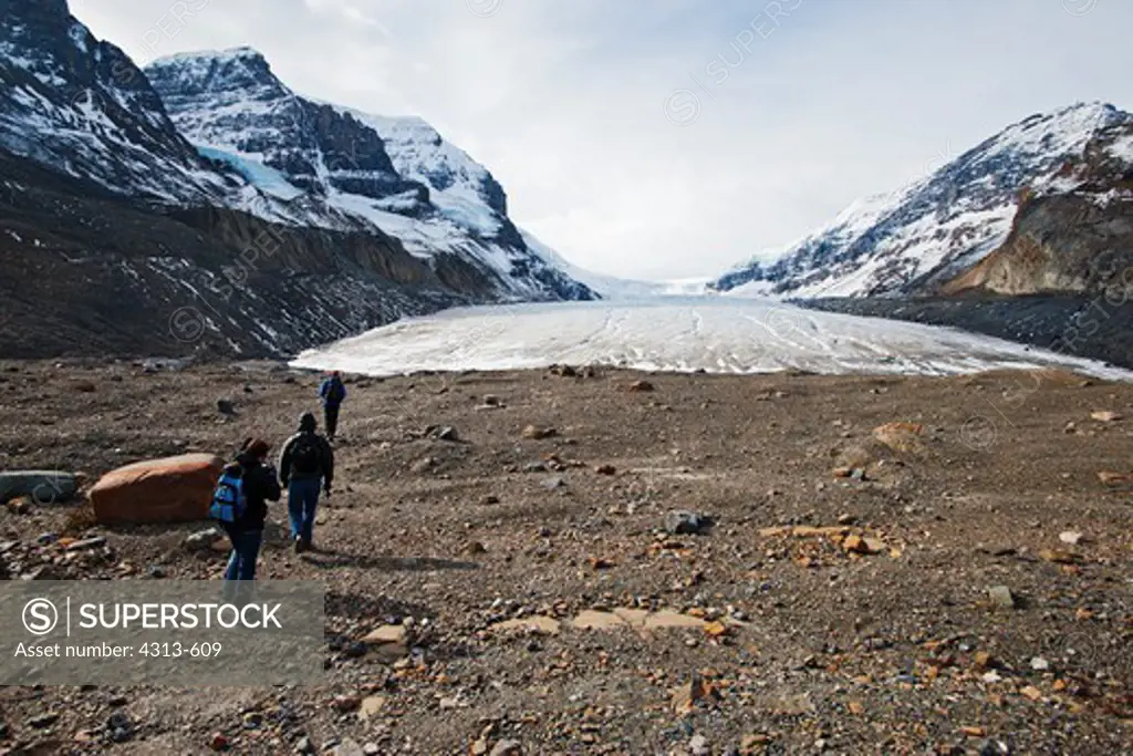 Hikers approach the terminus of Athabasca Glacier. Athabasca Glacier occupied most of the valley in the 1960s, but in the last fifty years global warming has melted most of it. It may be gone by 2030.